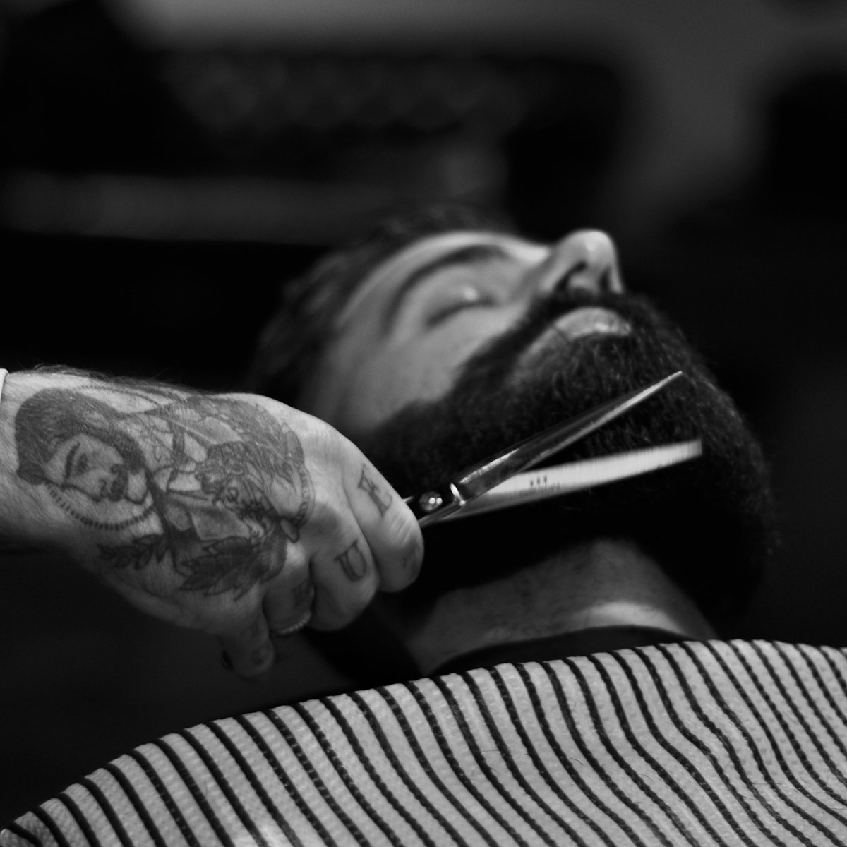Scissors shaping a full beard, black and white
