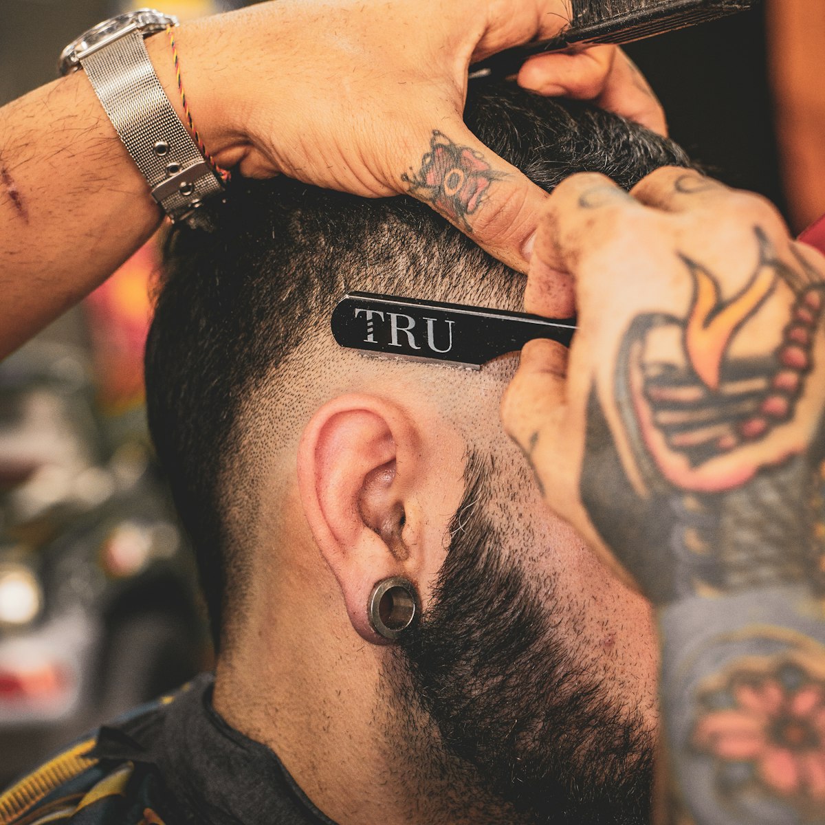 Straight razor cleaning up a taper behind the ear